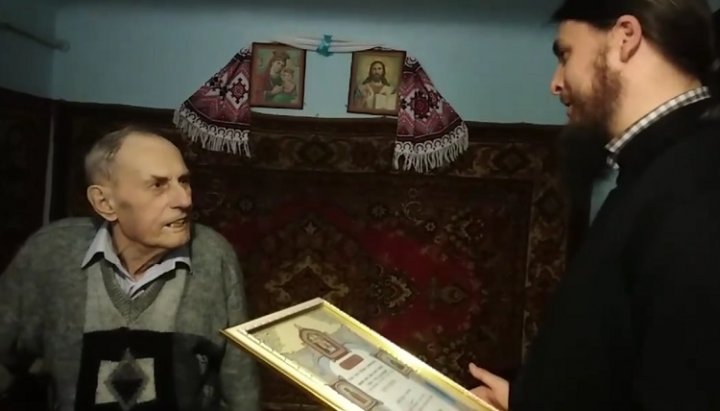 Пономаря Василия Драгомарецкого поздравляют с 90-летием и вручают награду с грамотой от Предстоятеля УПЦ. Фото: скриншот видео со страницы прихода Успенского храма УПЦ в Михальче в Facebook.