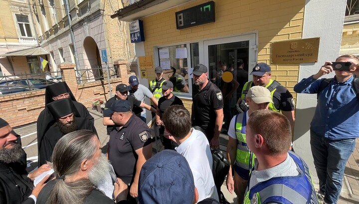 Ченці Києво-Печерської лаври та співробітники поліції біля будівлі Господарського суду Києва. Фото: telegram-канал «Лавра Сейчас»