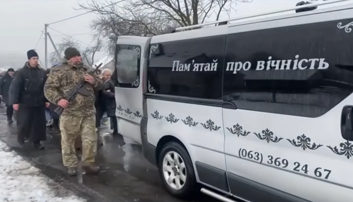 Священник УПЦ идет за машиной с телом погибшего воина. Фото: скриншот ФБ Подгайцевской теробщины