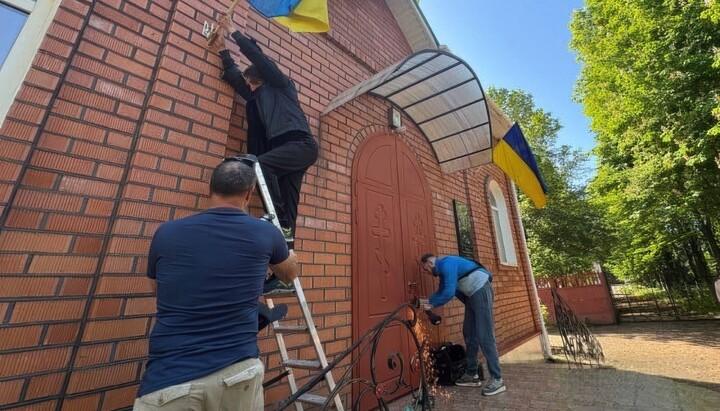 Активисты срезают замки на Пантелеимоновском храме УПЦ. Фото: 1kr.ua